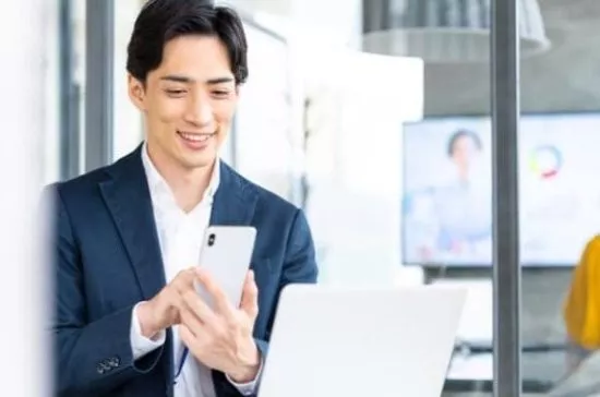 カードローンの金利をスマホで調べている男性